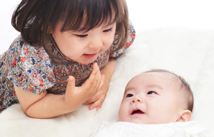 生まれて間もない赤ちゃんと姉